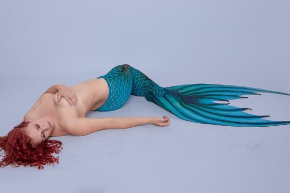 A topless sexy mermaid representing a paraplegic woman.